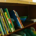 Kolorowe książki dla dzieci na drewnianej półce w bibliotece