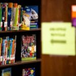Półka w bibliotece w Pszczynie z kolorowymi książkami dla dzieci