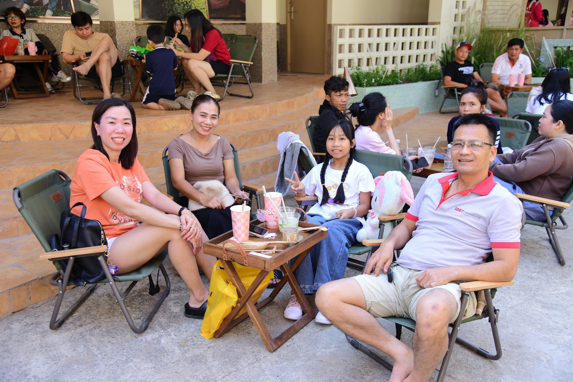 Rodzina z dziećmi pije napoje w ogródku kawiarni w Pszczynie