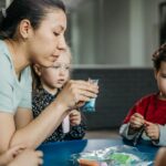 Nauczycielka bawi się przy stoliku z grupą przedszkolaków