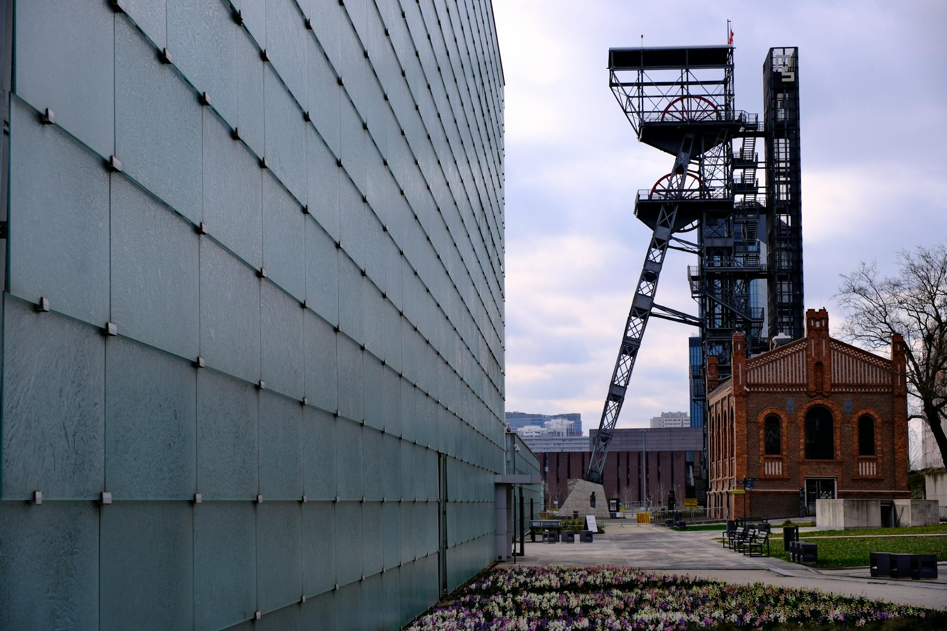 Weekend w Katowicach: trasa zwiedzania modernistycznych zabytków i industrialnych pereł województwa śląskiego Nowoczesny szklany biurowiec obok ceglanej zabudowy poprzemysłowej