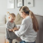 Mama i córka bawią się i śmieją w przytulnym domu